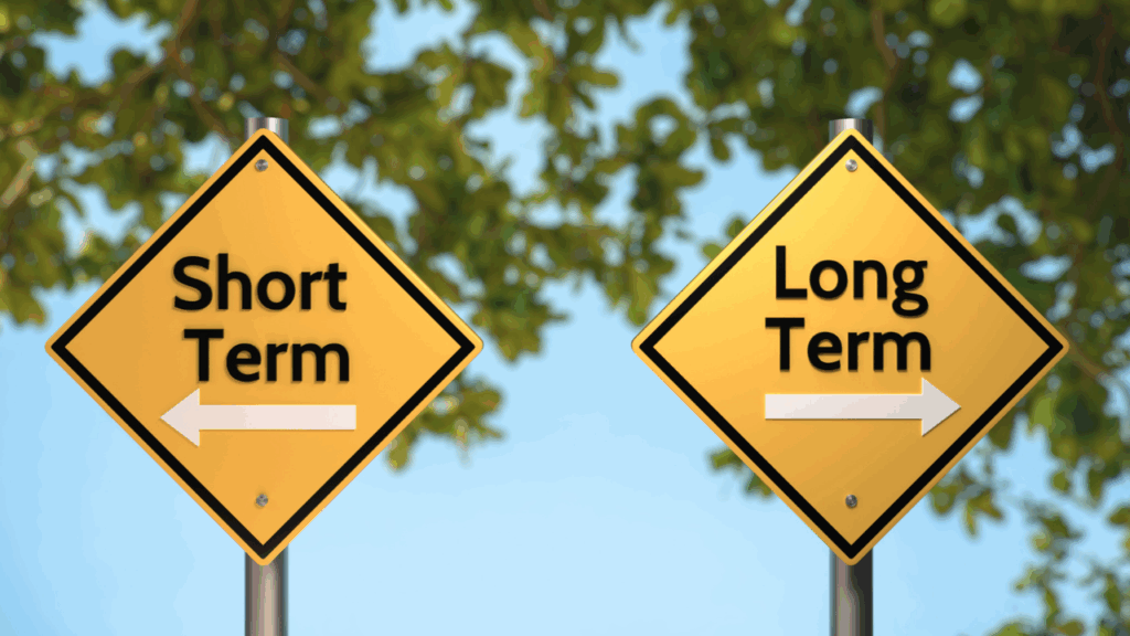 two road signs pointing to long term or short term in opposite directions